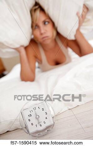 Young woman in bed with pillow on her head View Large Photo Image Stock Photography - Young woman in bed with pillow on her head. Fotosearch