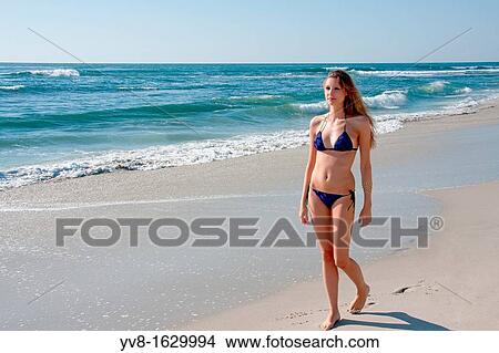 Young woman in bikini walking at the beach View Large Photo Image Picture - Young woman in bikini walking at the beach. Fotosearch