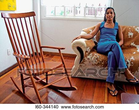Stock Image - Young woman in blue at home. Fotosearch