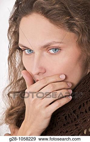 young woman in brown stopping her mouth with her hand, too shy to express herself, or regretting her words View Large Photo Image Stock Photo - young woman in brown stopping her mouth with her hand, too shy to express herself, or regretting her words. Fotosearch