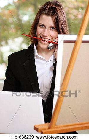 Young woman in business attire painting, talking on phone and checking on laptop at the same time View Large Photo Image Stock Photo - Young woman in business attire painting, talking on phone and checking on laptop at the same time. Fotosearch