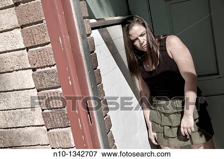 Young woman in front of a door View Large Photo Image Stock Photo - Young woman in front of a door. Fotosearch