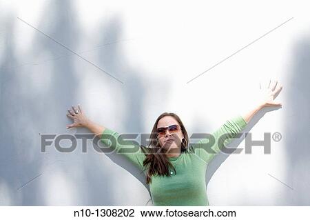 Young woman in front of a wall View Large Photo Image Stock Image - Young woman in front of a wall. Fotosearch