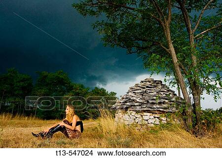 Young woman in front of Istrian? kazun? stone hut just before the storm, Croatia, Europe View Large Photo Image Picture - Young woman in front of Istrian? kazun? stone hut just before the storm, Croatia, Europe. Fotosearch