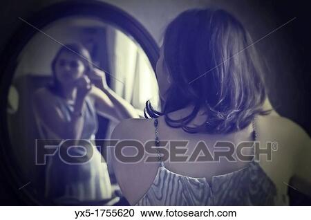 Young woman in front of the mirror View Large Photo Image Stock Image - Young woman in front of the mirror. Fotosearch