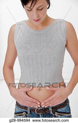 young woman in grey top with hands on her stomach View Large Photo Image Picture - young woman in grey top with hands on her stomach. Fotosearch