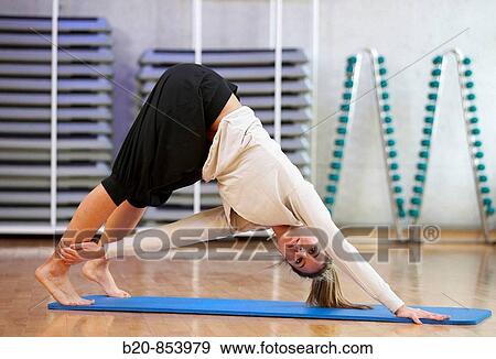 Young woman in gym doing yoga View Large Photo Image Stock Photo - Young woman in gym doing yoga. Fotosearch