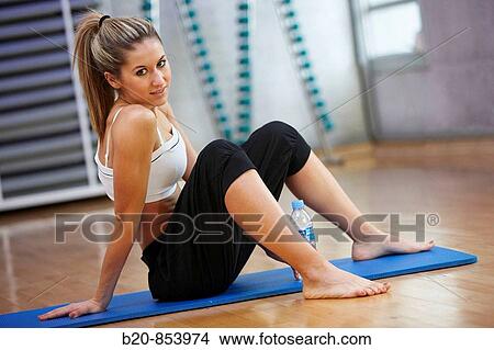 Young woman in gym resting and drinking water View Large Photo Image Picture - Young woman in gym resting and drinking water. Fotosearch