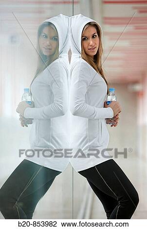 Young woman in gym resting and drinking water View Large Photo Image Stock Image - Young woman in gym resting and drinking water. Fotosearch