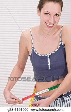 Young woman in her bathroom, measuring herself with a tape measure View Large Photo Image Stock Image - Young woman in her bathroom, measuring herself with a tape measure. Fotosearch