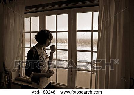 young woman in interior standing in front of completely flooded with water window, Atlantic ocean, beach front hotel room in February, heavy rain and wind, Peniche, Portugal View Large Photo Image Stock Image - young woman in interior standing in front of completely flooded with water window, Atlantic ocean, beach front hotel room in February, heavy rain and wind, Peniche, Portugal. Fotosearch