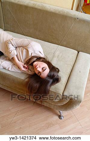 Young woman in jeans sleeping on sofa View Large Photo Image Picture - Young woman in jeans sleeping on sofa. Fotosearch
