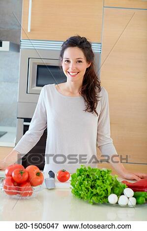 Stock Photo - Young woman in kitchen. Fotosearch