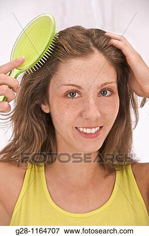 Stock Photo - young woman in lime colour brushing her hair. Fotosearch