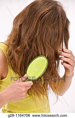 Stock Photo - young woman in lime colour brushing her hair. Fotosearch