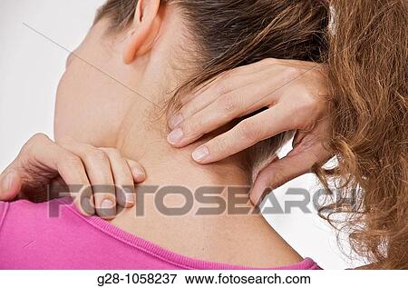 Stock Photo - young woman in pink suffering from a stiff neck, or a pain in the back. Fotosearch