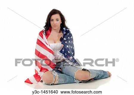 Stock Image - Young woman in ripped jeans wrapped in american flag. Fotosearch