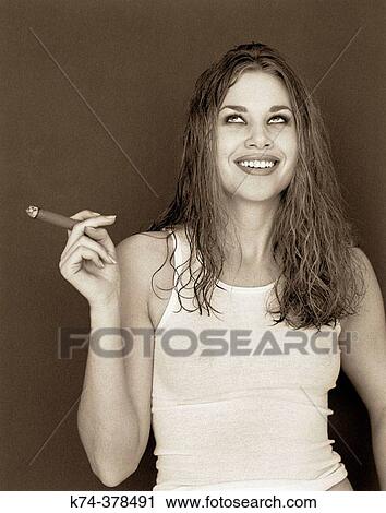 Young woman in tank top and panties smoking a cigar View Large Photo Image Stock Image - Young woman in tank top and panties smoking a cigar. Fotosearch