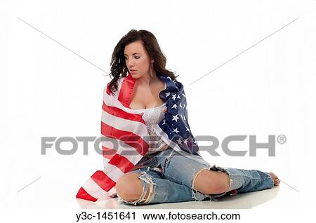 Stock Image - Young woman in teenager outfit wrapped in american flag. Fotosearch