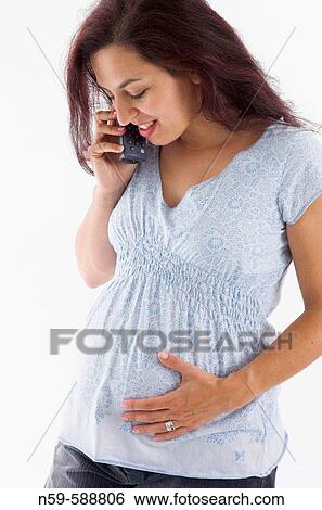 Young woman in the early stages of pregnancy shares her exciting news on the telephone View Large Photo Image Stock Photograph - Young woman in the early stages of pregnancy shares her exciting news on the telephone. Fotosearch