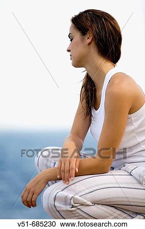 Young woman in white clothes looking at the sea View Large Photo Image Stock Image - Young woman in white clothes looking at the sea. Fotosearch