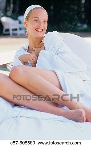 Young woman in white robe, poised on lounge chair at outdoor poolside View Large Photo Image Stock Image - Young woman in white robe, poised on lounge chair at outdoor poolside. Fotosearch
