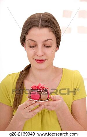 Young woman in Yellow holding a cake View Large Photo Image Stock Photo - Young woman in Yellow holding a cake. Fotosearch