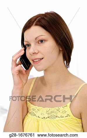 Young woman in yellow, using a portable phone View Large Photo Image Stock Image - Young woman in yellow, using a portable phone. Fotosearch