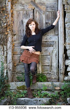 Young woman inclined on old wooden door View Large Photo Image Stock Photograph - Young woman inclined on old wooden door. Fotosearch