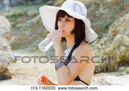 Young woman is drinking fresh water from a plastic bottle View Large Photo Image Stock Image - Young woman is drinking fresh water from a plastic bottle. Fotosearch