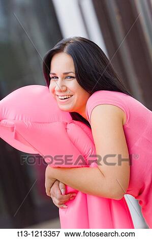 Young woman is embracing an inflated floating raft and laugh openly View Large Photo Image Stock Photo - Young woman is embracing an inflated floating raft and laugh openly. Fotosearch
