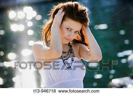 Stock Photo - Young woman is holding her hair. Fotosearch