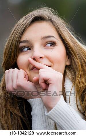Young woman is mimicking? silence? with a finger View Large Photo Image Stock Photo - Young woman is mimicking? silence? with a finger. Fotosearch