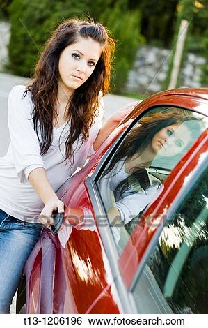 Young woman is opening a door of the car View Large Photo Image Stock Photograph - Young woman is opening a door of the car. Fotosearch