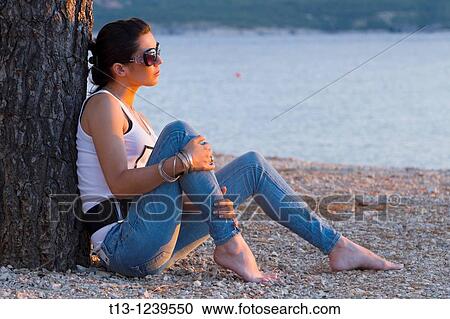 Young woman is resting watching sunset View Large Photo Image Stock Image - Young woman is resting watching sunset. Fotosearch