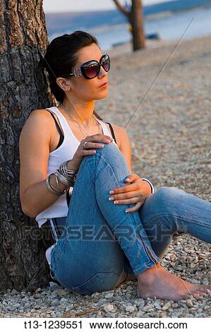 Young woman is resting watching sunset View Large Photo Image Stock Image - Young woman is resting watching sunset. Fotosearch