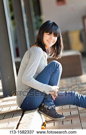 Young woman is sitting on the pavement edge View Large Photo Image Stock Photo - Young woman is sitting on the pavement edge. Fotosearch