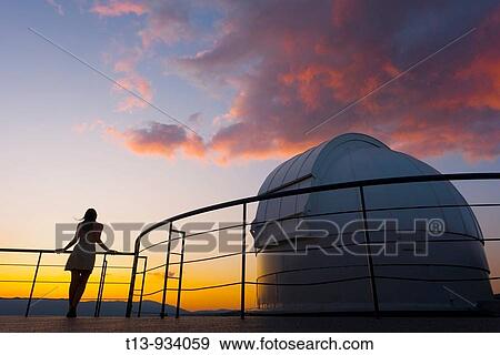 Young woman is standing next to space observatory telescope dome in sunset View Large Photo Image Stock Photo - Young woman is standing next to space observatory telescope dome in sunset. Fotosearch