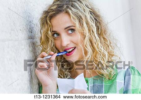 Picture - Young woman is taking notes. Fotosearch