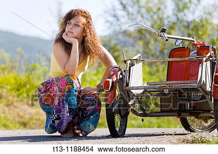 Young woman is waiting for a helping hand with a flat tire View Large Photo Image Picture - Young woman is waiting for a helping hand with a flat tire. Fotosearch