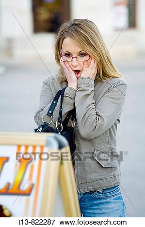 Young woman is wondering about the high prices listed on outdoor restaurant table View Large Photo Image Stock Photo - Young woman is wondering about the high prices listed on outdoor restaurant table. Fotosearch