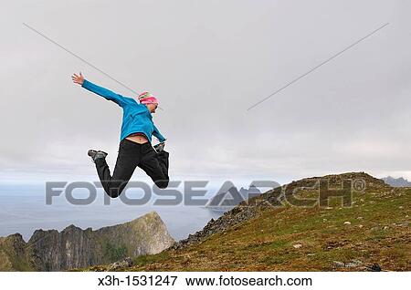 young woman jumping at the top of the Husfjellet mountain, Senja island County of Troms, Norway, Northern Europe View Large Photo Image Stock Photo - young woman jumping at the top of the Husfjellet mountain, Senja island County of Troms, Norway, Northern Europe. Fotosearch