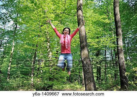 Young woman jumping in air laughing low angle view View Large Photo Image Stock Photo - Young woman jumping in air laughing low angle view. Fotosearch