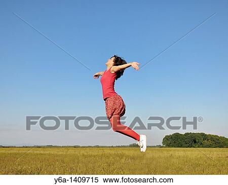 Young woman jumping in air View Large Photo Image Stock Photography - Young woman jumping in air. Fotosearch