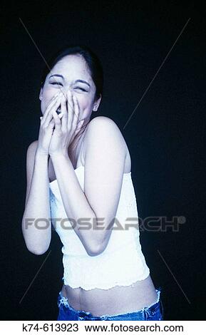 young woman laughing with hands over mouth View Large Photo Image Stock Image - young woman laughing with hands over mouth. Fotosearch