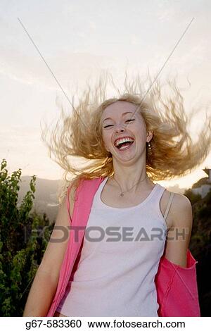 Young woman laughs as she tosses her hair back. View Large Photo Image Stock Image - Young woman laughs as she tosses her hair back.. Fotosearch