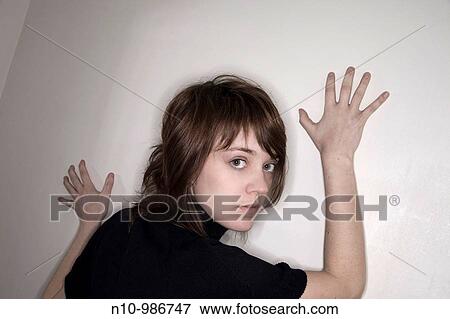 Young woman leaning against a wall View Large Photo Image Stock Photo - Young woman leaning against a wall. Fotosearch