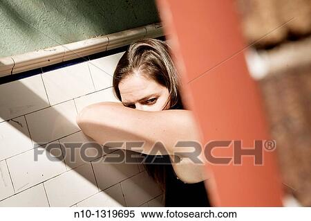 Young woman leaning against a wall View Large Photo Image Stock Photography - Young woman leaning against a wall. Fotosearch