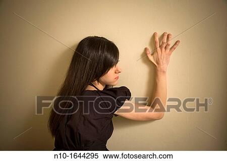 Young woman leaning against a wall View Large Photo Image Stock Photography - Young woman leaning against a wall. Fotosearch