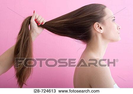 Young woman lifting hair, studio shot View Large Photo Image Stock Image - Young woman lifting hair, studio shot. Fotosearch